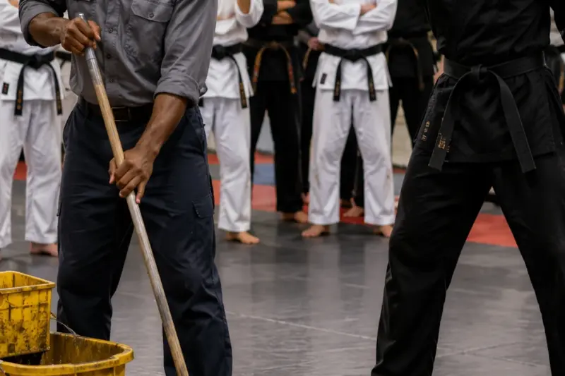 They Mocked The Janitor As If He Were Worthless. Then One Action Forced The Whole Dojo Into Silence. The Coach Believed He Was Shaming A Sweeper—Until He Saw Exactly Who Was Facing Him On The Mat